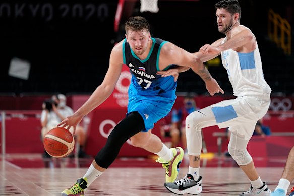 Luka Doncic drives up the court ahead of Argentina’s Patricio Garino.