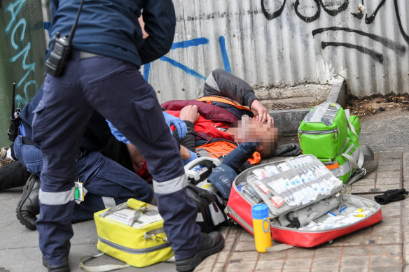 Paramedics attend to an overdose on Victoria Street last week.