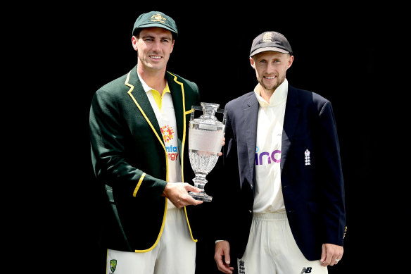 Australian captain Pat Cummins and England captain Joe Root pose up with an Ashes trophy.