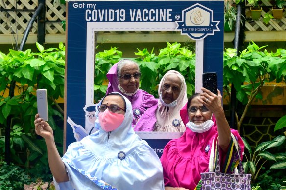 Women in Mumbai take post-vaccination selfies outside a hospital in March.
