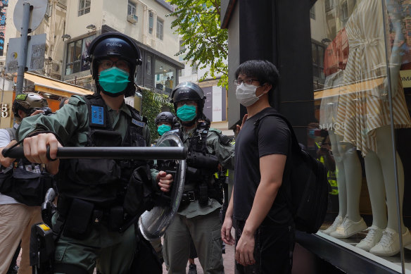 Police check pedestrians gathered in the Central district of Hong Kong on May 27. 