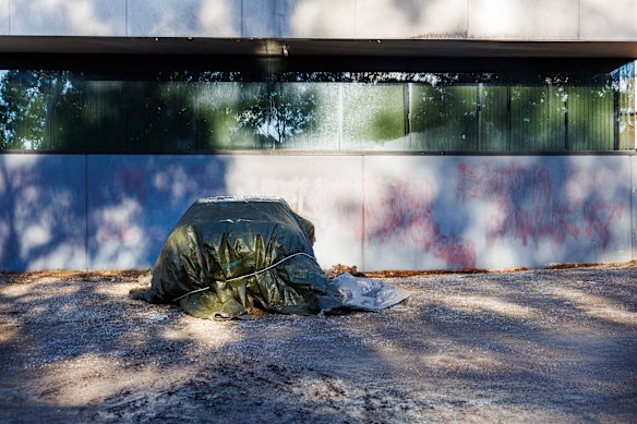 A damaged car on Saturday and evidence of old graffiti on a wall at Lovitt Technologies Australia in Greensborough.