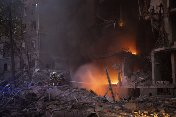 Firefighters try to put out a fire following an explosion in Kyiv, Ukraine.
