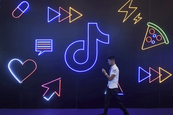 A man walks past a display for Douyin, the Chinese version of video-sharing app TikTok.