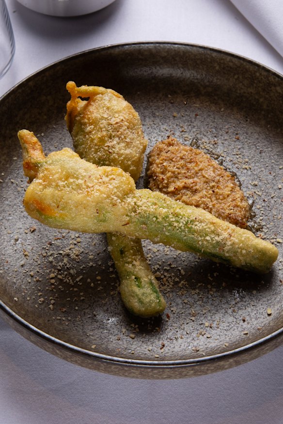 Mozzarella-stuffed fried zucchini flowers with smoked almond.