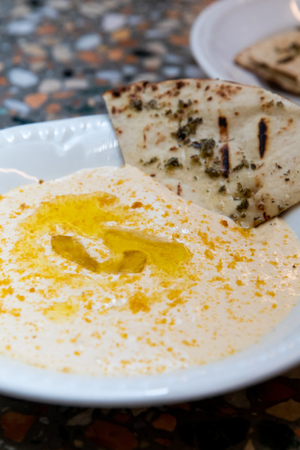 Fresh pita bathing in hummus.