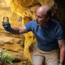 Water scientist Ian Wright takes a sample of PFAS-contaminated water in a sandstone canyon at Greaves Creek, below Medlow Dam.