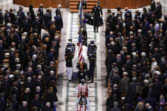 A military bearer team carries the casket at the funeral for former secretary of state Colin Powell. 