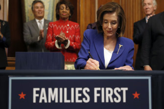 House Speaker Nancy Pelosi signs the Coronavirus Aid, Relief, and Economic Security Act.
