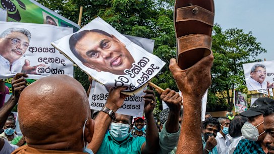 Thousands demonstrate against the government of Gotabaya Rajapaksa, seen in signs at left and right, over power cuts and the lack of essential products in Colombo.