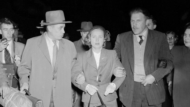 "Weeping and obviously near collapse, Mrs Petrov was tightly gripped by a Russian bodyguard who led her across the tarmac at Mascot last night. The Russian courier, Mr V. Karpinsky (left), who arrived from Moscow last Thursday, held Mrs Petrov's other arm."