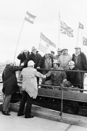 Historic moment - workers shake hands as the West Gate Bridge joins up, 1978.