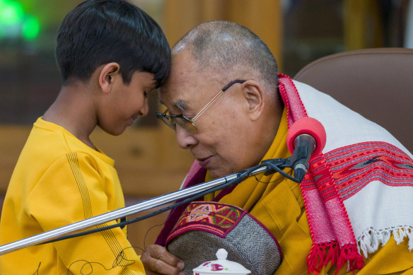 Tibetli ruhani lider Dalai Lama, Hindistan'ın Dharamshala kentindeki Tsuglakhang tapınağında bir grup öğrenciye hitap etmeden önce genç bir çocuğun alınlarına dokunuyor.