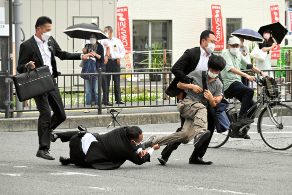 Police tackle the suspected gunman after Shinzo Abe was shot on Friday.  