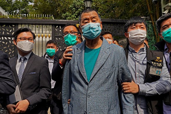 Jimmy Lai, al centro, è stato arrestato dagli agenti di polizia nella sua casa di Hong Kong nel 2020.