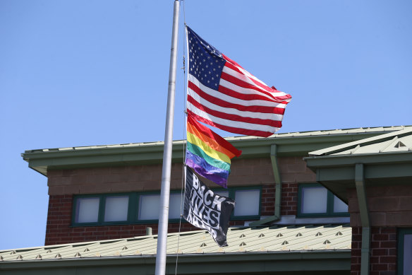 The US flag, the rainbow pride flag and a Black Lives Matter flag fly over the Nativity School of Worcester, Massachusetts. 