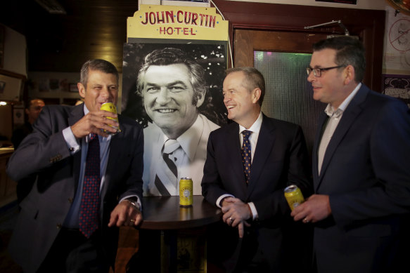 Former premier Steve Bracks, then-opposition leader Bill Shorten and Premier Daniel Andrews share a beer in memory of former prime minister Bob Hawke at The Curtin in 2019, after the death of Mr Hawke.