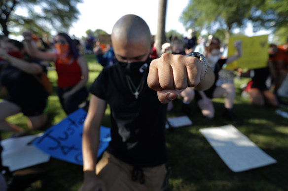 Boris Garcia kneels for over eight minutes to remember George Floyd at a protest in Richardson, Texas.