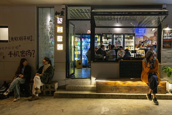 Young people linger outside a 24-hour bar attached to a youth hostel in Dali.