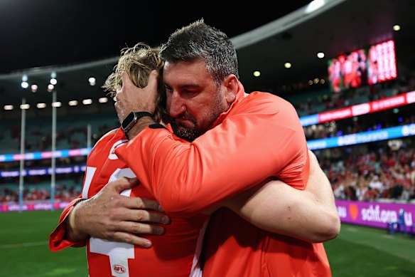 Callum Mills of the Swans embraces Swans head coach Dean Cox