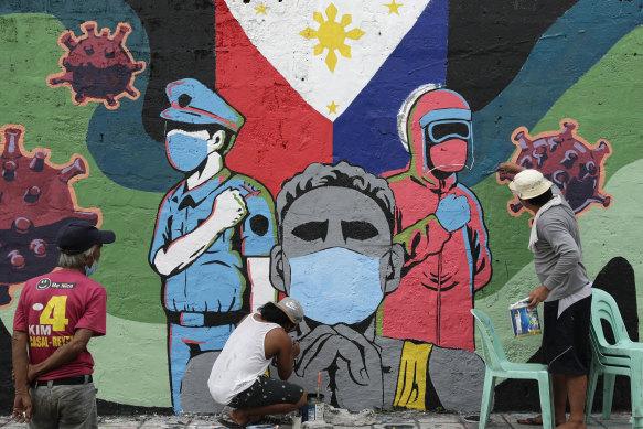 Residents put the finishing touches on a mural to honour front-line workers in Makati city, Philippines.