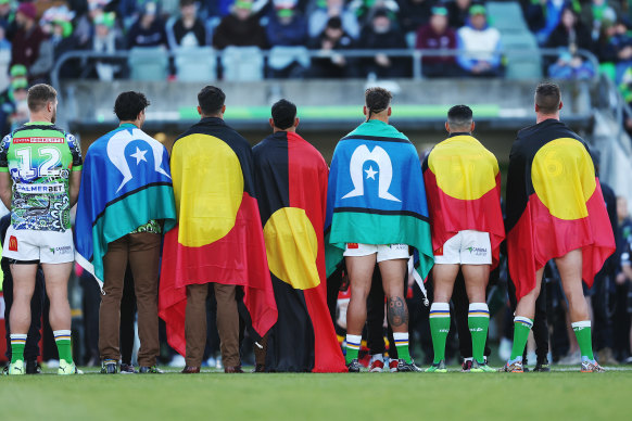 Canberra Raiders players with Aboriginal and Torres Strait Islander flags before their Indigenous Round game last week.