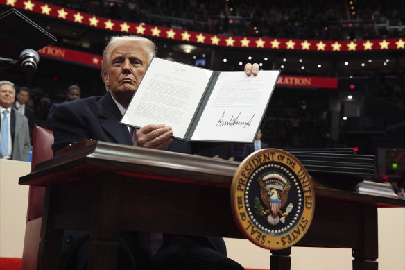 President Donald Trump signs an executive order at Capital One Arena in Washington.