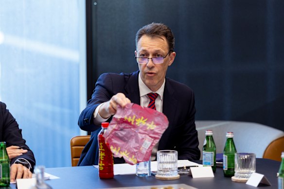 Visy chief Mark De Wit showing an imported drink bottle with a PVC wrapper that contaminates plastic recycling.