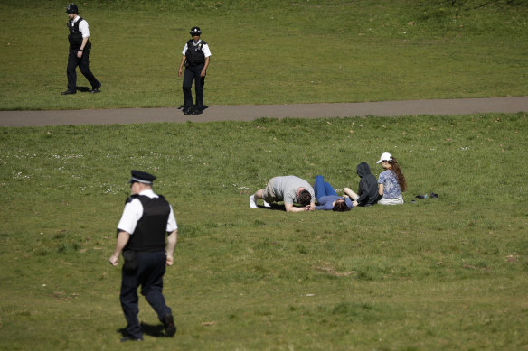 Police officers ask people to move on in Greenwich Park in London on Sunday.