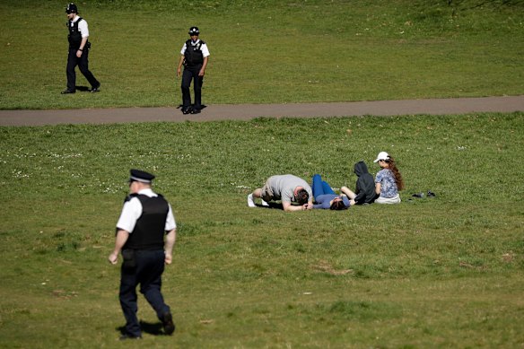 Police officers ask people to move on in Greenwich Park in London on Sunday.