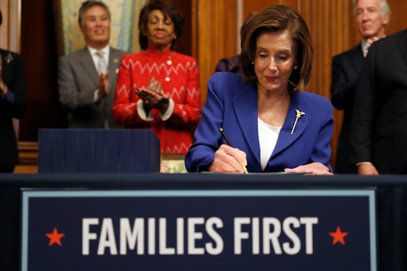 House Speaker Nancy Pelosi signs the Coronavirus Aid, Relief, and Economic Security Act.
