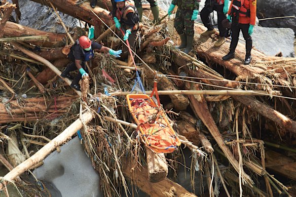 Rescuers retrieve the body of a flood victim in West Sumatra on Monday.