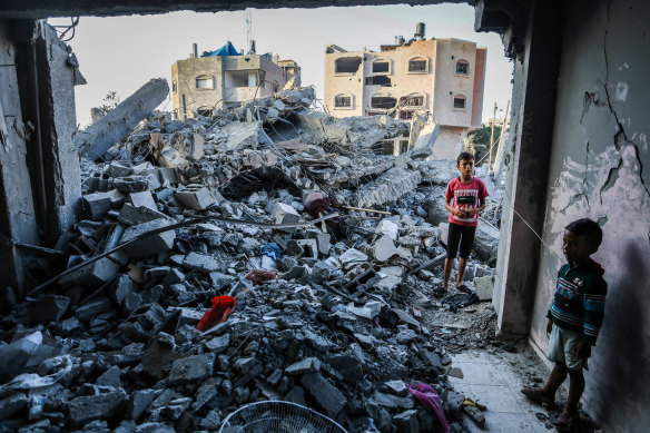 Children stand in a building destroyed during Israeli air raids in the southern Gaza Strip, on November 6. Thousands of children have been killed in the air raids.