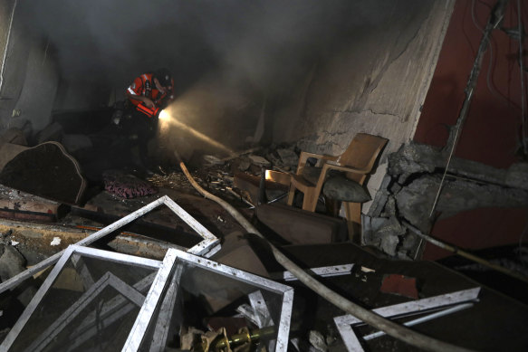 A Palestinian civil defence crew looks through a house that was hit by an Israeli airstrike.