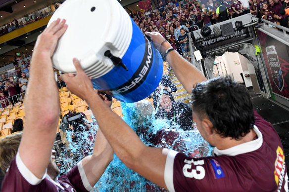 Maroons coach Wayne Bennett has an ice bucket poured on him by Tino Fa'asuamaleaui and Christian Welch.