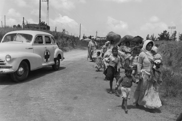 Arab civilians, helped by the Red Cross, move out of the Jewish sector of Jerusalem c 1948.