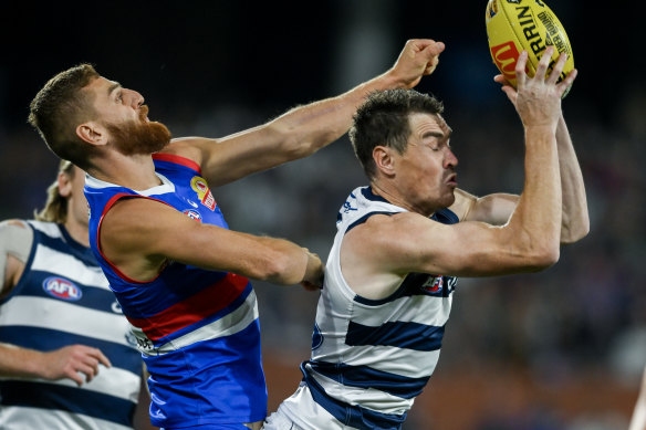 Jeremy Cameron of the Cats marks in front of Liam Jones of the Bulldogs.