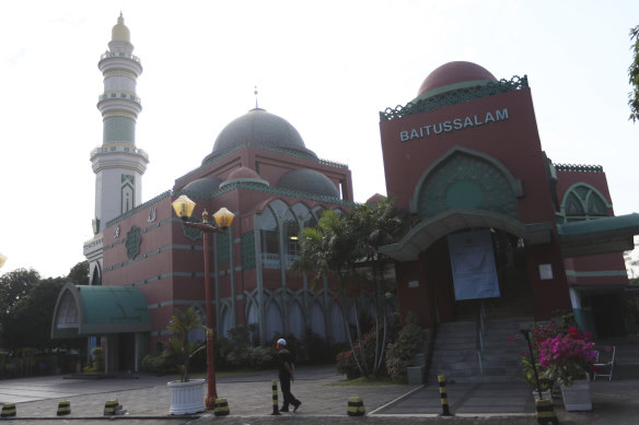 A man walks near a mosque in Jakarta, Indonesia.