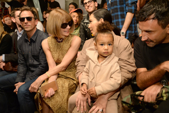 North, the daughter of Kim Kardashian West and Kanye West, sitting with her mother at a fashion show in 2015.