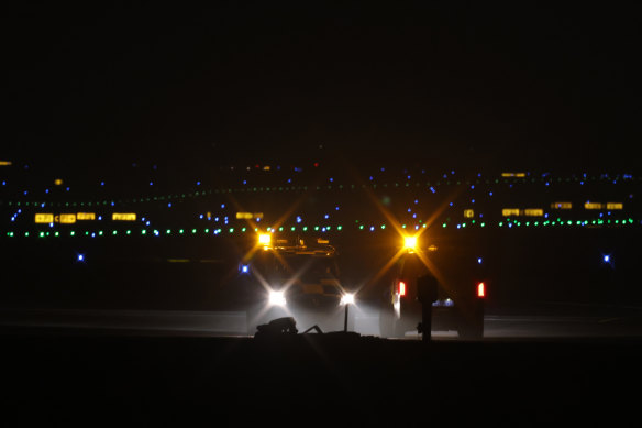 24 Kasım'da BER Berlin-Brandenburg Uluslararası Havalimanı'ndaki asfaltta yanıp sönen ışıklı havaalanı araçları duruyor.