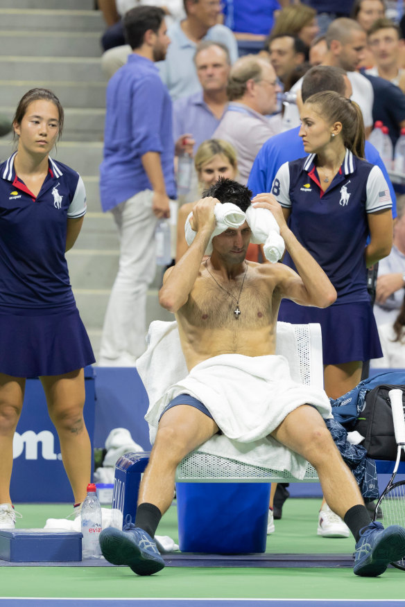 Pre-ice bath: Djokovic uses a "neck sausage" and damp lap towel to cool off during the US Open in 2018.