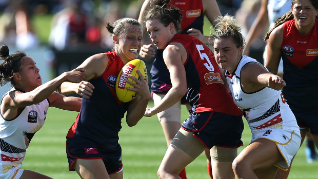 With a characteristic burst of power, Melbourne footballer Karen Paxman breaks through traffic.