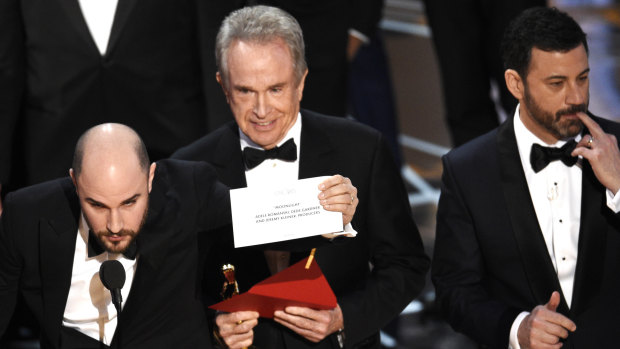 Jordan Horowitz shows the envelope revealing Moonlight as the real winner of best picture at the Oscars last year as Warren Beatty and Jimmy Kimmel look on. 