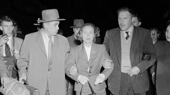 "Weeping and obviously near collapse, Mrs Petrov was tightly gripped by a Russian bodyguard who led her across the tarmac at Mascot last night. The Russian courier, Mr V. Karpinsky (left), who arrived from Moscow last Thursday, held Mrs Petrov's other arm."