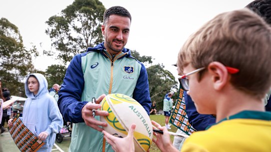 Wallabies star Tom Wright signs autographs at a fan day in Sydney. 