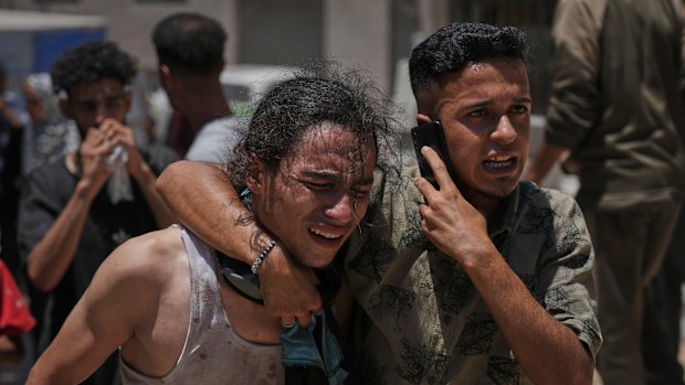 Palestinians react after carrying the bodies of those killed while trying to reach aid trucks entering northern Gaza.