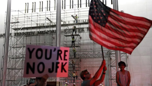 People wait for President Donald Trump’s name to be removed from the centre.