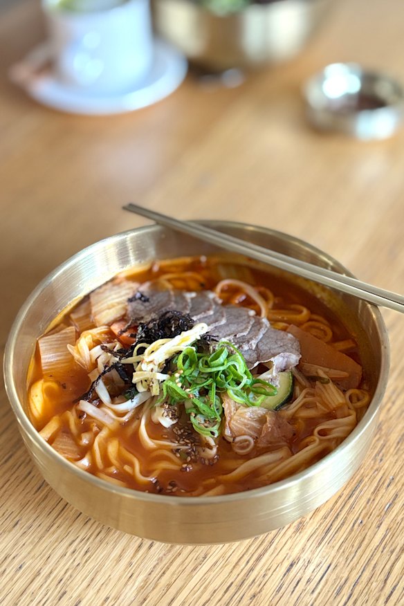 Misty Pot’s kimchi kalguksu (knife-cut noodle soup) topped with braised beef.