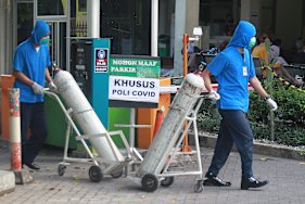 Medical workers wheel oxygen tanks at Dr Sardjito Central Hospital in Yogyakarta