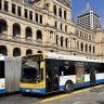 Buses pass the Treasury Building in the Brisbane CBD.